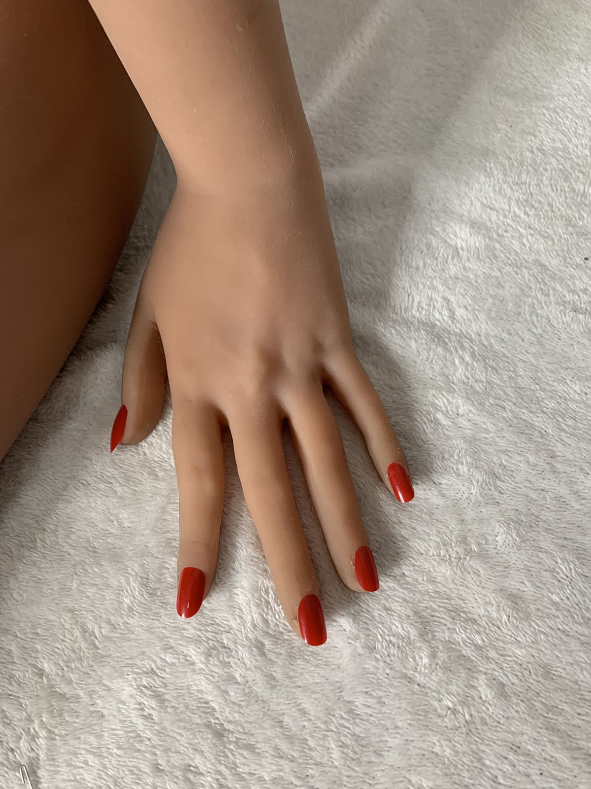 Sex doll hand with red nail polish