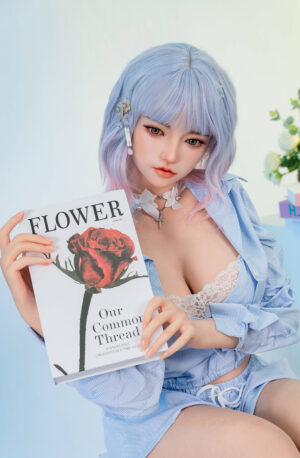 Life sized cute young lifelike sex doll holding a book in the study