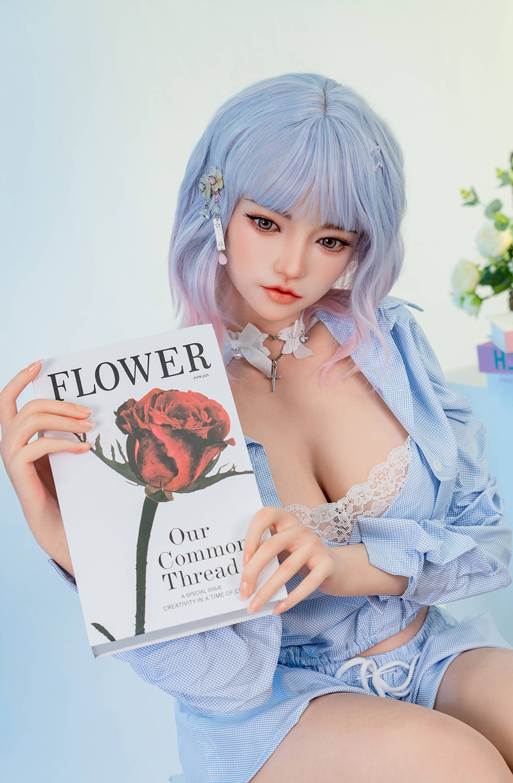 Life sized cute young lifelike sex doll holding a book in the study